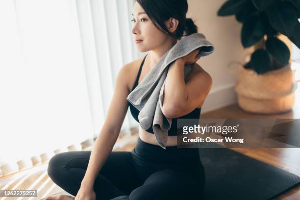 young woman feeling good after workout at home - after workout towel happy stock pictures, royalty-free photos & images