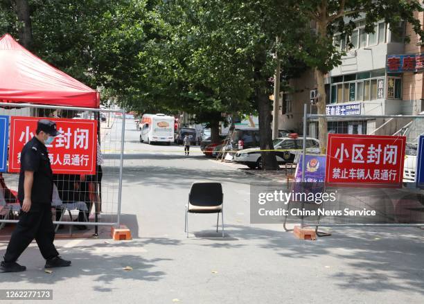 Security guard stands at the entrance of a closed residential community on July 29, 2020 in Dalian, Liaoning Province of China.