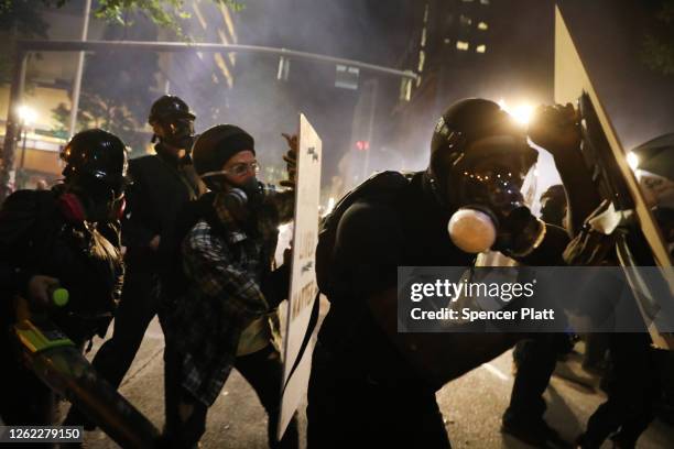 Protesters clash with federal police in front of the Mark O. Hatfield federal courthouse in downtown Portland as the city experiences another night...