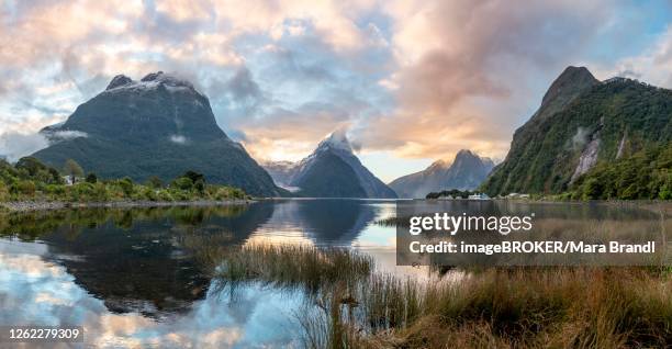 mitre peak, reflection in water, sunset, milford sound, fiordland national park, te anau, southland, south island, new zealand - te anau stock pictures, royalty-free photos & images