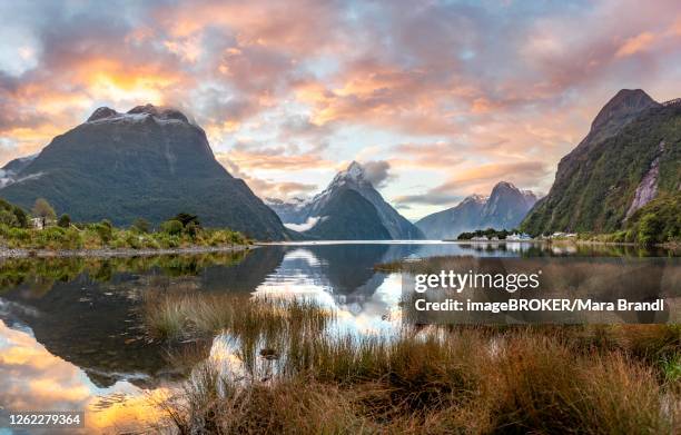 mitre peak, reflection in water, sunset, milford sound, fiordland national park, te anau, southland, south island, new zealand - te anau stock pictures, royalty-free photos & images