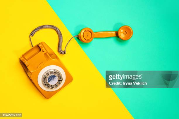 yellow handset of a retro telephone on yellow and mint green background. - telefonlur bildbanksfoton och bilder