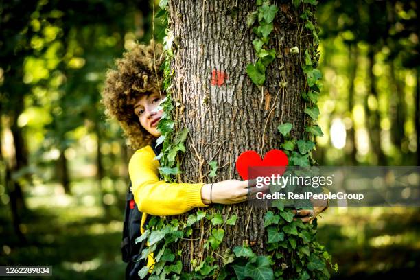 hände umarmen einen stamm eines baumes im sommerpark oder wald mit sonnenlicht. ökologie, liebevolles naturkonzept - happy earth day stock-fotos und bilder