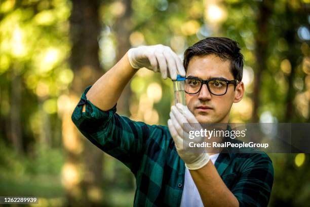 young ecologist man in the forest - specimen holder stock pictures, royalty-free photos & images