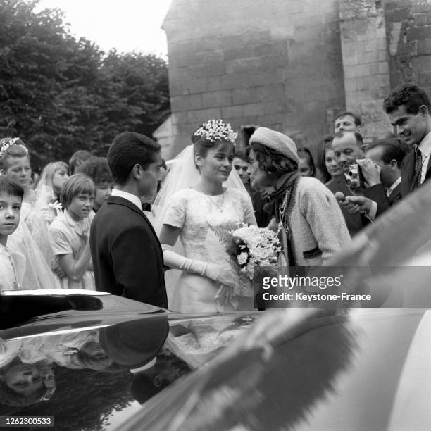 Coco Chanel, la témoin de mariage, félicitant les jeunes époux à la sortie de l'église à Gouvieux, France le 3 août 1964.