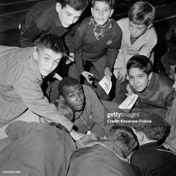 Roger Bambuck très entouré par des enfants après sa victoire du 200 mètres, à Fontainebleau, France le 27 septembre 1964.