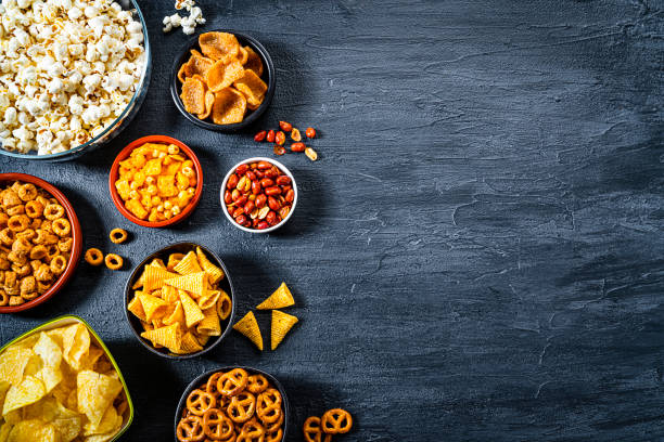 salty snacks assortment shot from above on dark slate table. copy space - savory food stock pictures, royalty-free photos & images