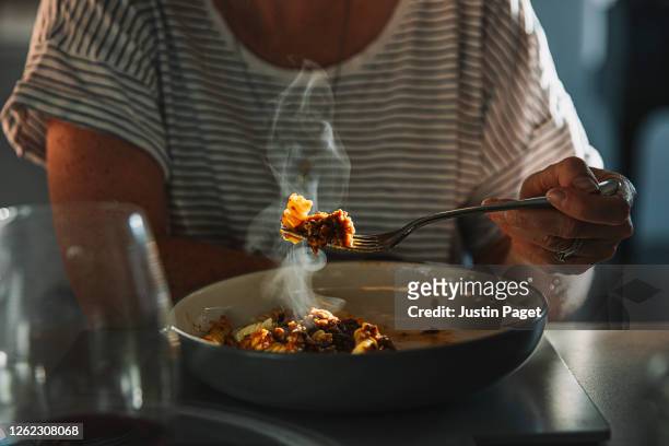 woman eating fusilli pasta with bolognese sauce - savory sauce stockfoto's en -beelden