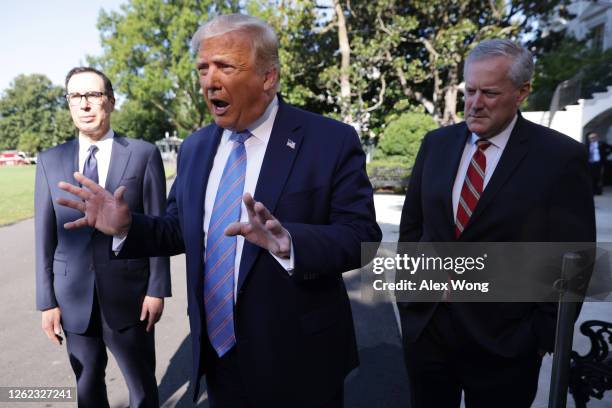 President Donald Trump speaks as Secretary of Treasury Steven Mnuchin and White House Chief of Staff Mark Meadows listen prior to Trump's Marine One...