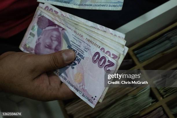 Detail as a man counts Turkish Lira at a currency exchange office on July 29, 2020 in Istanbul, Turkey. The Turkish Lira remains under pressure after...