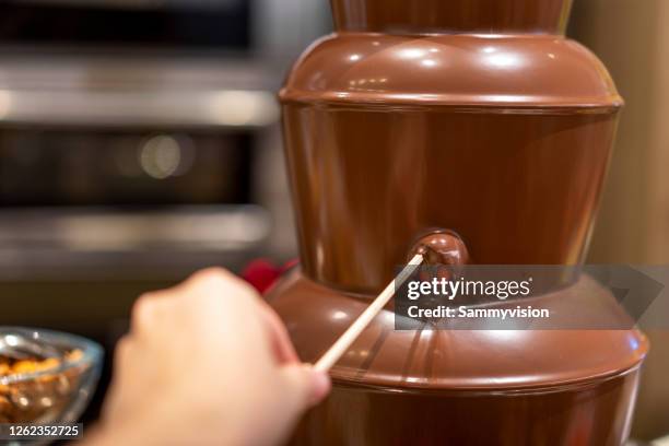 dipping fruit in chocolate fountain - chokladfondue bildbanksfoton och bilder