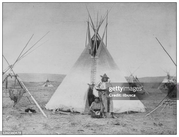 antique black and white photo: native encampment on the sarcee reserve - native american reservation stock illustrations