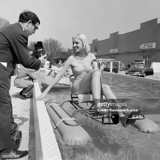 Installée sur un pédalo, une jeune Londonienne, Gillian Ashbee, inaugure la piscine du salon du camping et du caravaning, à Paris, France le 12 avril...