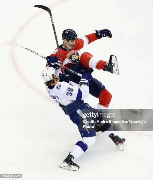 Mikhail Sergachev of the Tampa Bay Lightning checks Brian Boyle of the Florida Panthers in an exhibition game prior to the 2020 NHL Stanley Cup...