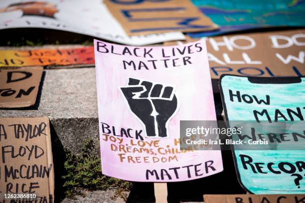 July 25: A line of homemade protest signs including one that says, "Black Lives Matter Black Joy, Love, Hope, Dreams, Children, Freedom, Matter" lay...