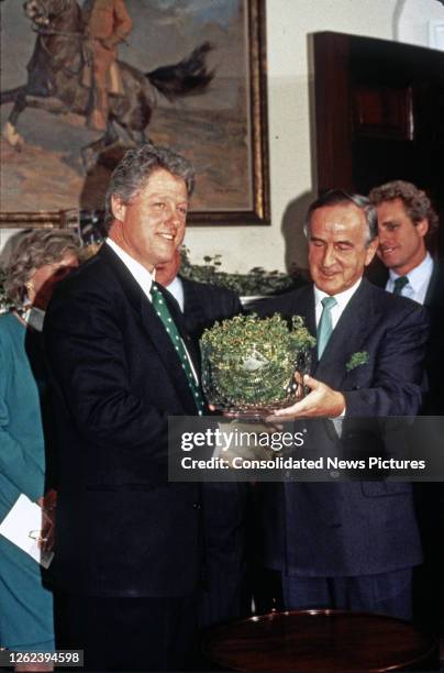 American politician US President Bill Clinton receives a traditional bowl of shamrocks from Irish Taoiseach Albert Reynolds during a ceremony...