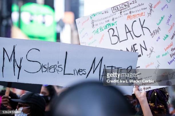 July 26: A protester holds a sign that say, "My Sister's Lives Matter" while another holds a sign that says, "Black Women Are.." with adjective to...
