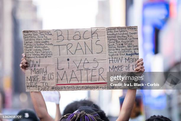 July 26: A protester holds a sign that say, "Black Trans Lives Matter" with the names of women that have died at the hands of police as they march in...