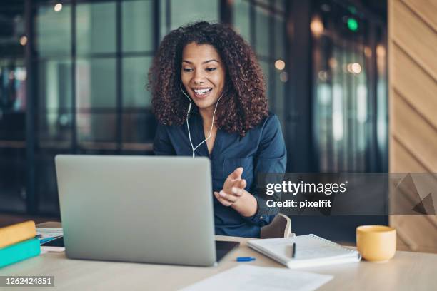 smiling businesswoman during a video call in the office - conference call imagens e fotografias de stock