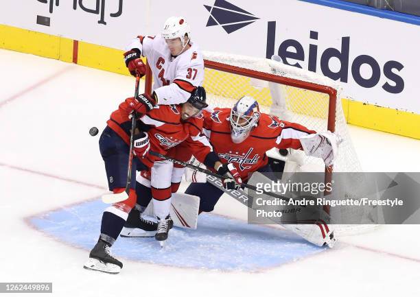 Brenden Dillon of the Washington Capitals and Andrei Svechnikov of the Carolina Hurricanes collide in front of Vitek Vanecek of the Capitals in the...