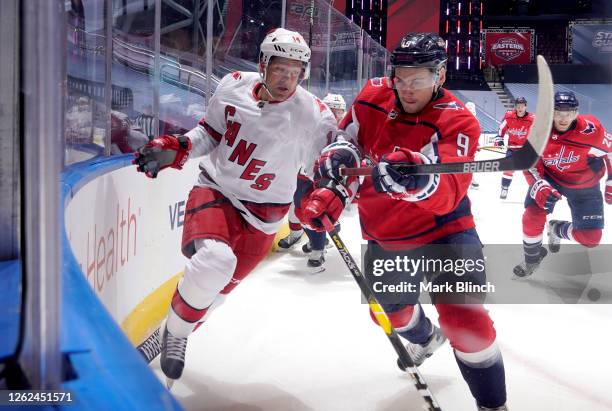 Justin Williams of the Carolina Hurricanes and Dmitry Orlov of the Washington Capitals battle at the boards during the exhibition game prior to the...