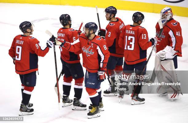 Dmitry Orlov and Alex Ovechkin of the Washington Capitals celebrate the win over the Carolina Hurricanes with teammates Michal Kempny, Nick Jensen,...