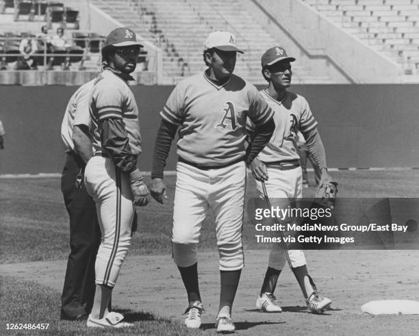 Left-to-right, Oakland Athletics right fielder Reggie Jackson, manager Alvin Dark, and shortshop Bert Campaneris review the field with the...