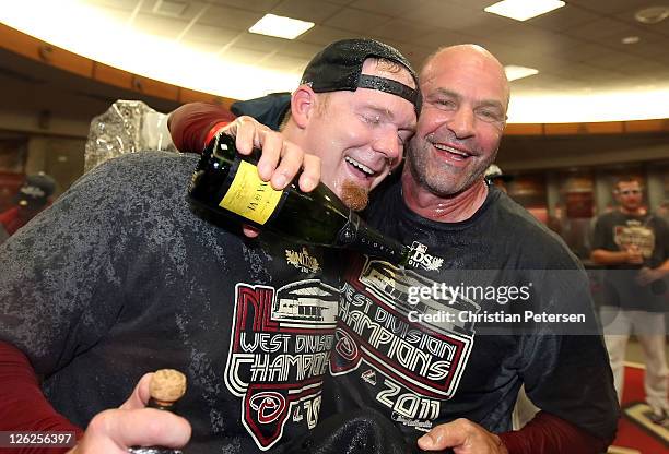 Pitcher J.J. Putz and manager Kirk Gibson of the Arizona Diamondbacks celebrate in the locker room after defeating the San Francisco Giants and...