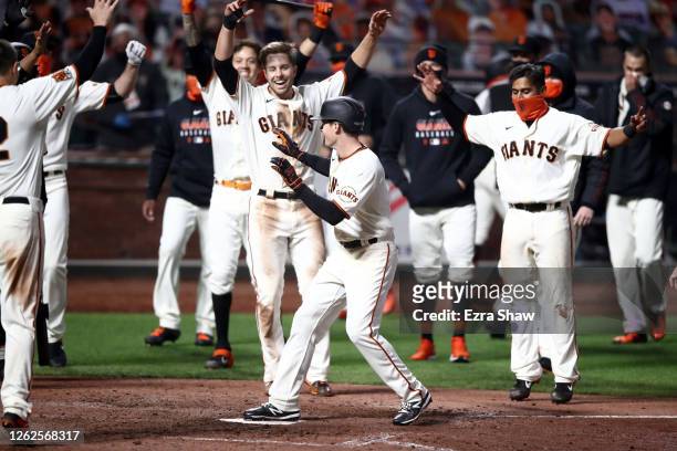 Mike Yastrzemski of the San Francisco Giants celebrates with teammates after he hit a walk-off home run in the ninth inning against the San Diego...