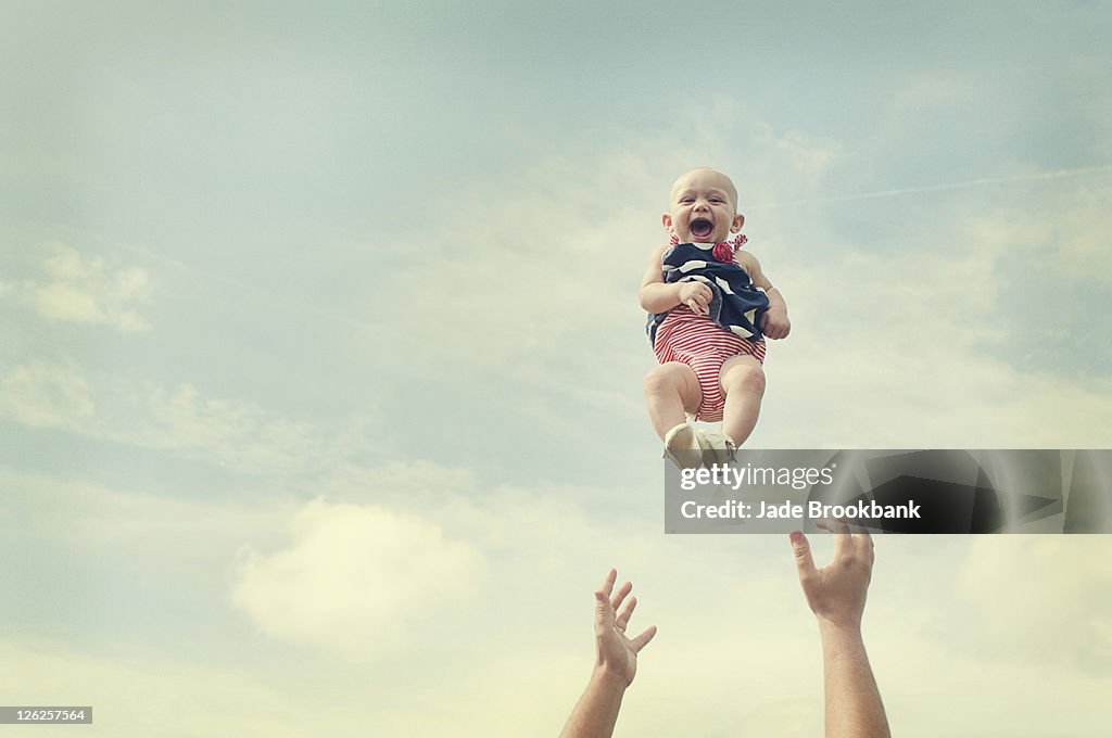 Man throwing baby in air