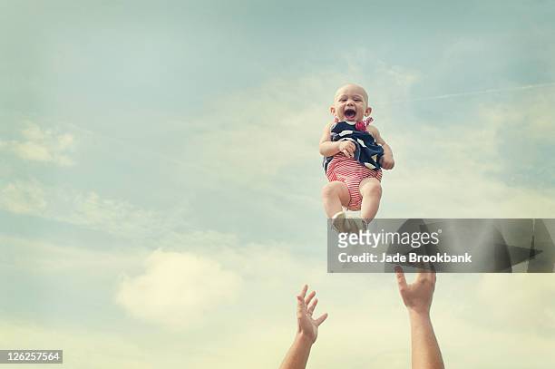 man throwing baby in air - throwing stock pictures, royalty-free photos & images