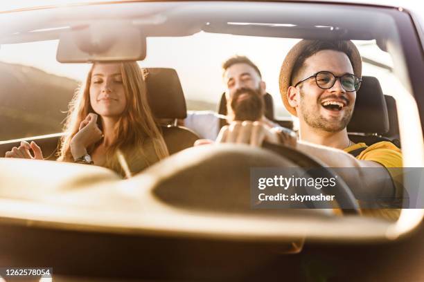 happy friends dancing and singing on a rod trip in convertible car. - couple singing stock pictures, royalty-free photos & images
