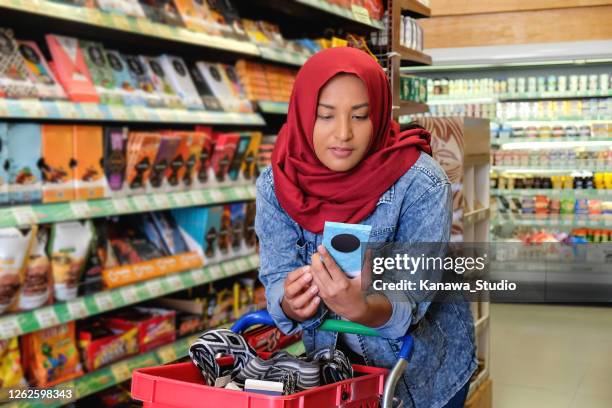 let's check the calories on this chocolate bar - asian woman shopping grocery stock pictures, royalty-free photos & images