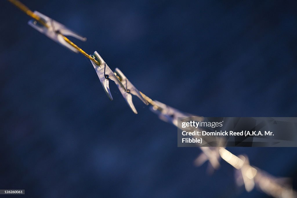 Pegs on a washing line against blue background