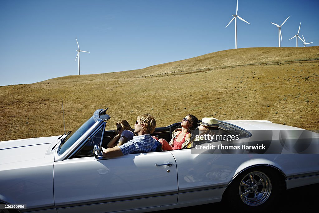 Friends resting in convertible parked on road