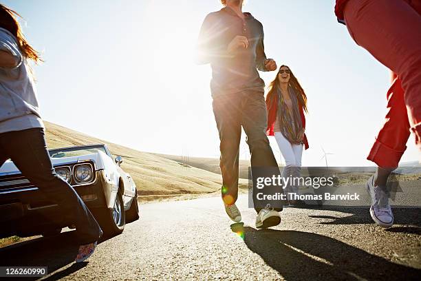 group of friends running on road at sunrise - newfriendship stock pictures, royalty-free photos & images