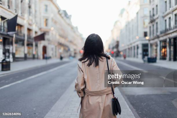 rear view of a young woman exploring and discovering regent street, london - vista posteriore foto e immagini stock