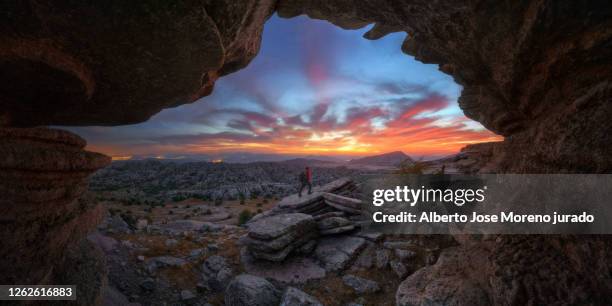 sunset in a beautiful landscape with person and orange clouds - paraje natural torcal de antequera stock pictures, royalty-free photos & images