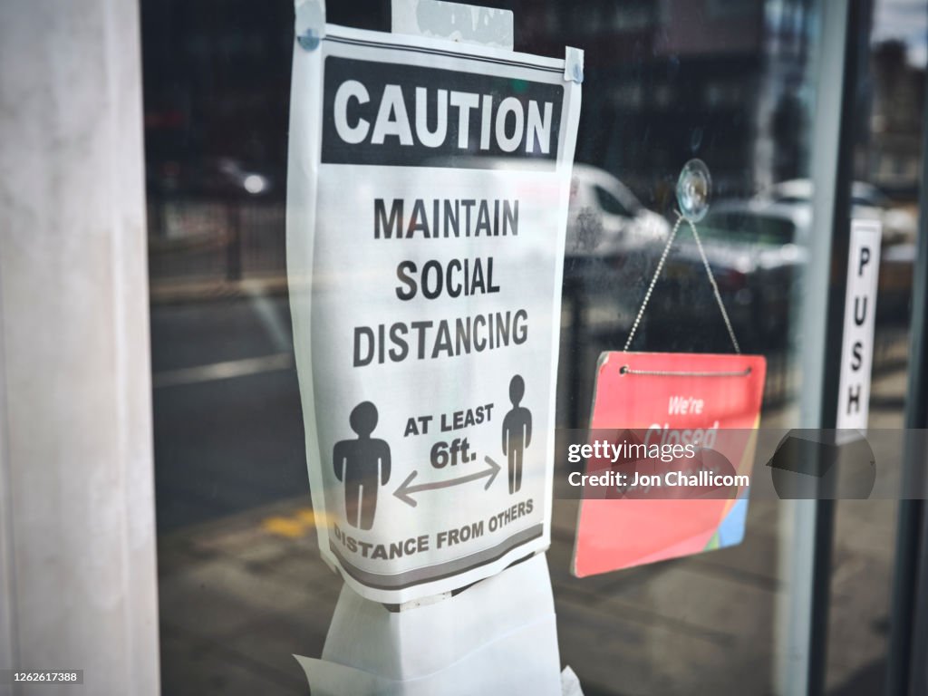 Social distancing / wearing mask signs, in shopfronts on a London high street