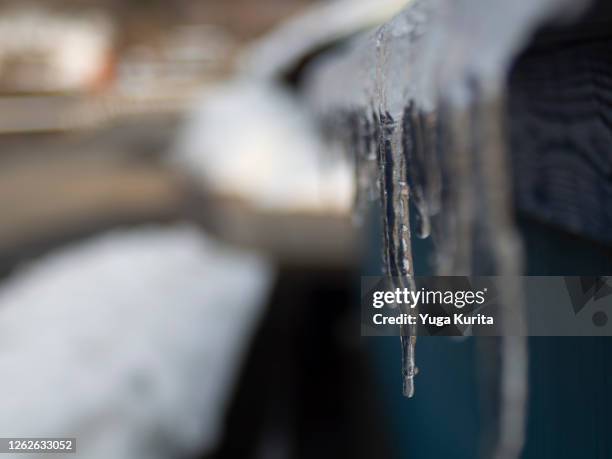 icicles under the eave being melted by the morning sunlight - meltwater stock pictures, royalty-free photos & images