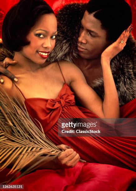 1980s 1970s African American Couple Man Wearing Fur Coat Woman Wearing Red Dress Looking At Camera