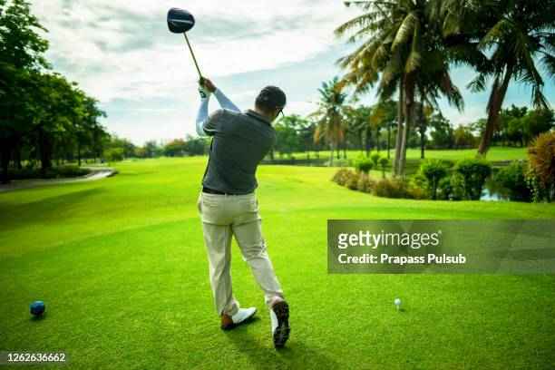 golfer putting golf ball on the green golf, lens flare on sun set evening time - tiro curto imagens e fotografias de stock