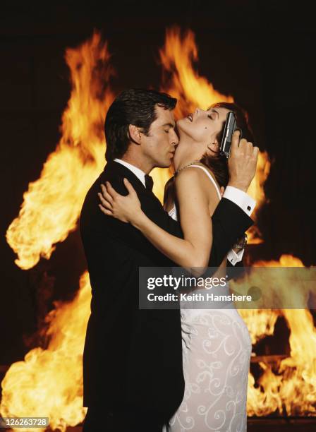 Irish actor Pierce Brosnan stars as James Bond opposite Polish actress Izabella Scorupco in the film 'GoldenEye', 1995. He is holding his iconic...