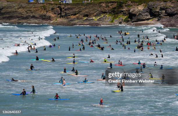 Tourists enjoy bodyboarding and surfing at the beach on July 30, 2020 in Polzeath, United Kingdom. Tourists are slowly returning to Cornwall after...