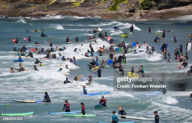 Tourists enjoy the beach on July 30, 2020 in Polzeath, United Kingdom. Tourists are slowly returning to Cornwall after lockdown measures introduced...