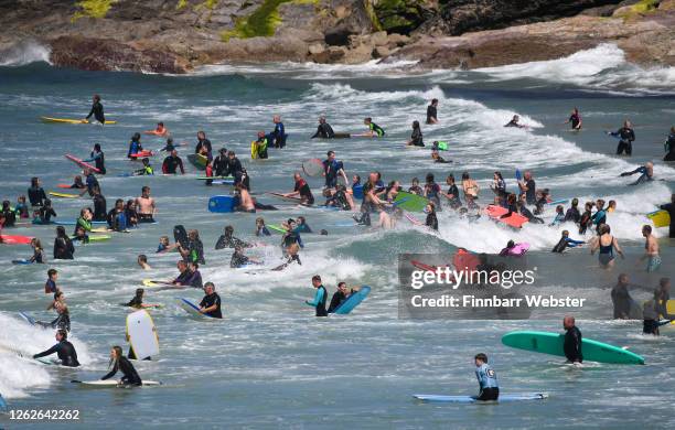 Tourists enjoy the beach on July 30, 2020 in Polzeath, United Kingdom. Tourists are slowly returning to Cornwall after lockdown measures introduced...