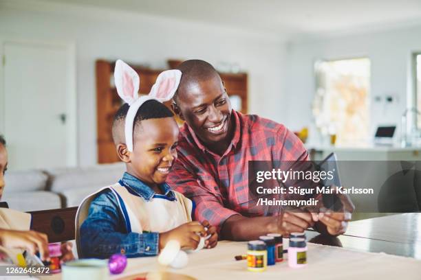 vader die selfies met zijn leuke kleine jongen neemt die konijnoren draagt - easter bunny man stockfoto's en -beelden