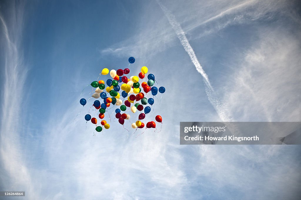 Balloons floating in blue sky