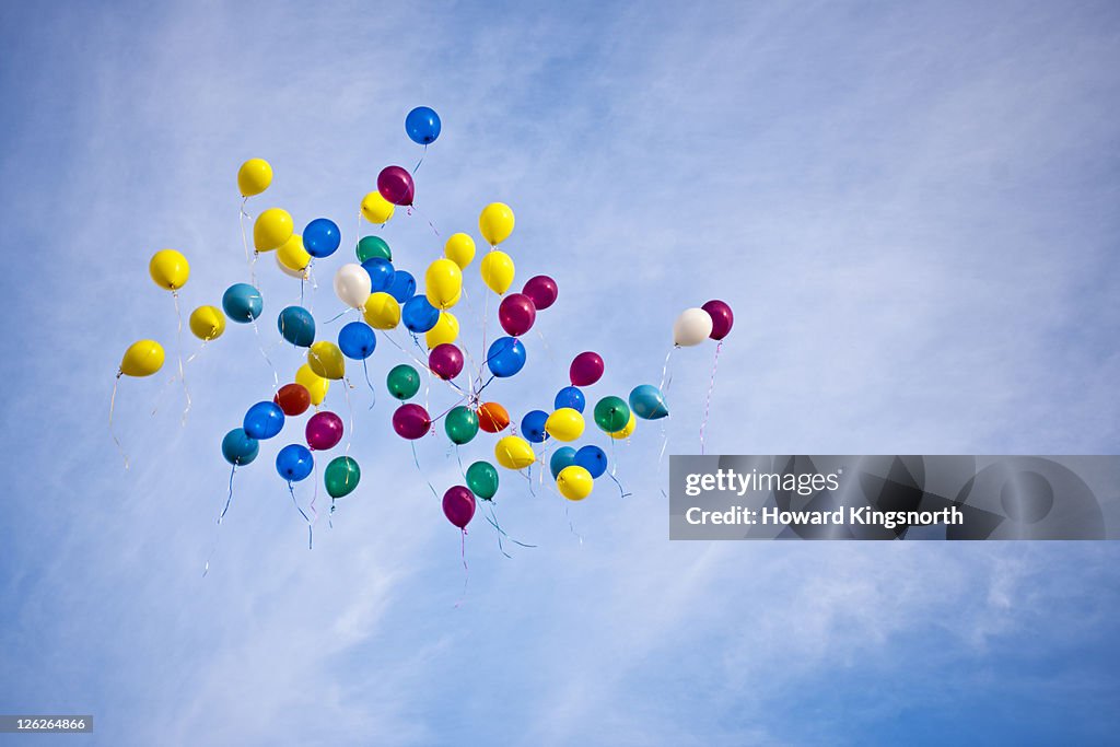Balloons floating in blue sky