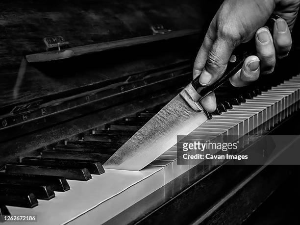 knife cutting a piano like a cake - broken musical instrument stock pictures, royalty-free photos & images